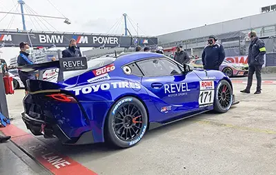 A blue Toyota Supra GT race car equipped with Toyo Proxes tires in the pit lane.