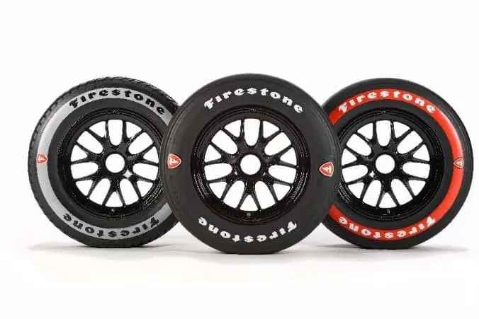 Three Firestone Firehawk IndyCar racing tires with alternate, primary, and red sidewall markings. 