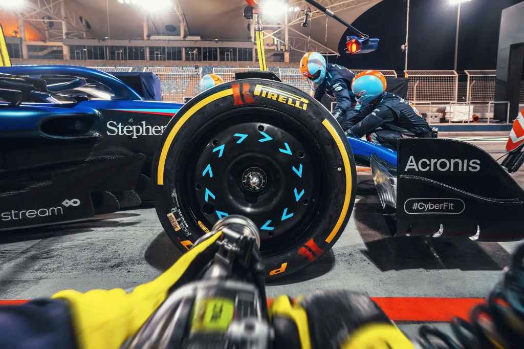 A close-up of a Pirelli P Zero race tire on a Formula 1 car during a pit stop.