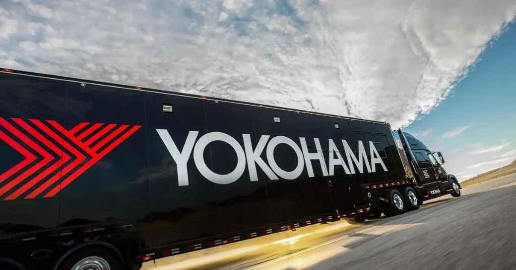 The black Yokohama Tires motorsports hauler driving on the highway.