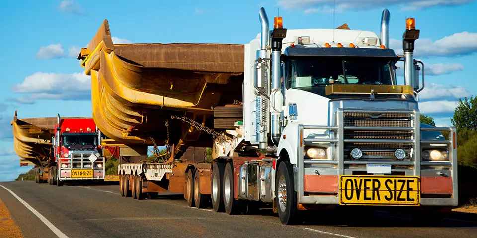 A heavy-haul truck with an oversize load, relying on durable Kelly commercial tires.