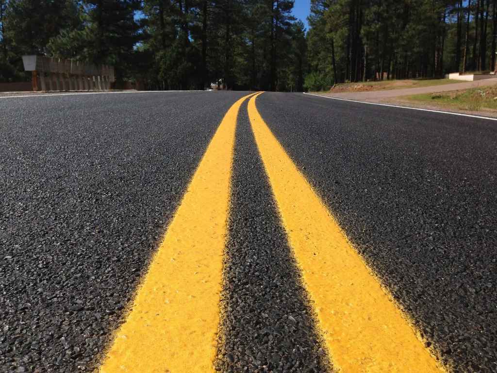 A low-angle view of a freshly paved highway, representing the open road for American Road Star tires. 